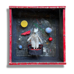 A mini handmade assemblage featuring a hand crafted space scene with painted planets with a central mouse figurine dressed in a white outfit within a red vintage cardboard cigar box.