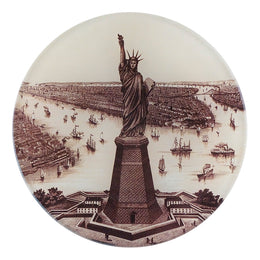 A five inch round glass plate featuring an illustration of the Statue of Liberty with a vintage print style.