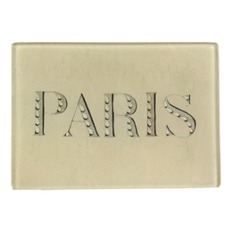 The word "PARIS" written in a light colore font with petal detail on a three and half inch by five inch glass tray.