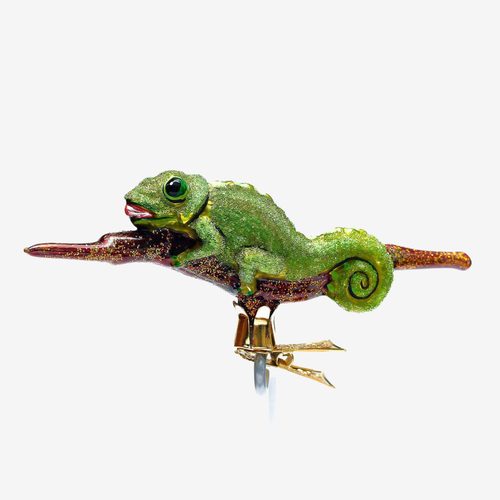 A green chameleon figurine perched on a brown branch with gold-toned feet, shown against a plain light gray background.