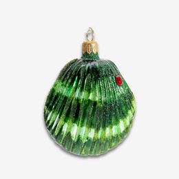 A green seashell-shaped Christmas ornament with glittery green stripes, a small red jewel detail, and a gold hanging loop, shown on a light gray background.