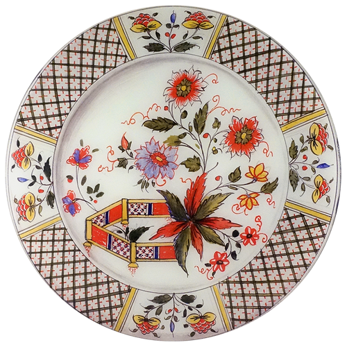 A 16-inch round glass plate featuring a red, yellow and blue flower drawing and a plaid pattern boarder. 
