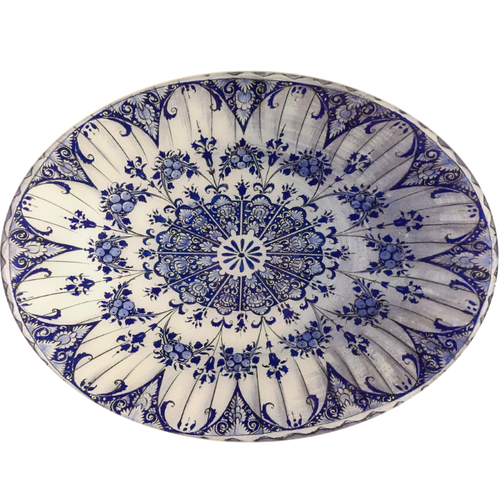 A fourteen inch by nineteen inch horizontal glass oval plate of a white and blue floral pattern featuring blueberries. 