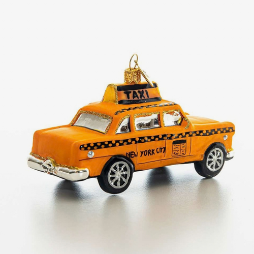 An orange New York City taxi cab ornament with black and yellow checkered details, silver trim, and a gold hanging loop on a white background.