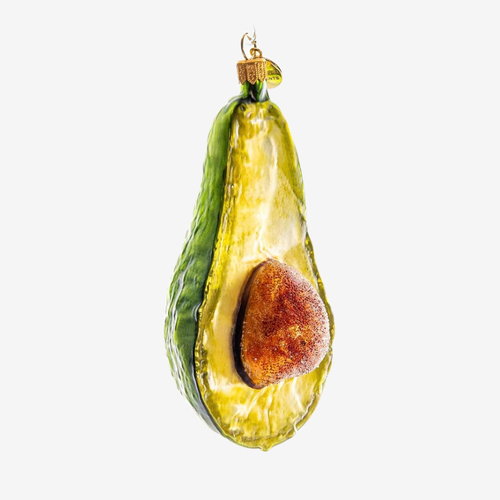An avocado-shaped hanging ornament with a glossy green skin, yellow-green flesh, and a brown pit, shown against a plain light gray background.