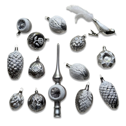 A set of silver-toned Christmas ornaments arranged on a white background, including textured pinecones, faceted balls, a bird ornament with a white feather, and a tall metallic finial.