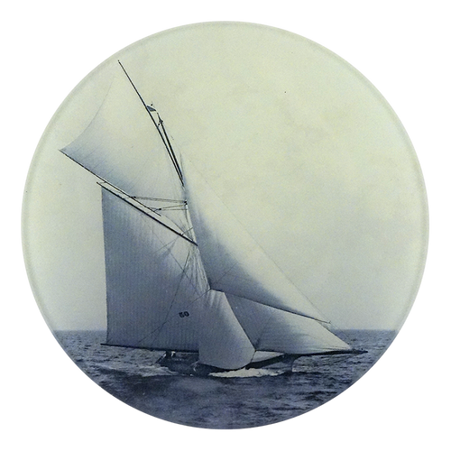 A five inch round plate featuring a vintage photograph of a sailboat on the water, printed in muted blue and cream tones, isolated on a white background