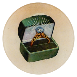 A five inch round handblown glass plate featuring a ring in a green box on a beige background