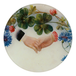 A five inch round glass plate featuring a close up of two people holding hands with flowers and clovers above the hands on a white background. 