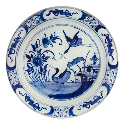 A five inch round glass plate of a blue and white delft design 