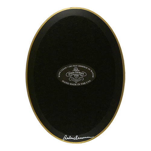 The back of a vertical 5 inch by 7 inch oval-shaped plate painted black with black felt backing and gold trim. Featuring the John Derian Company sticker and signed by John Derian. 