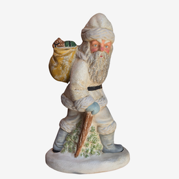 A vintage ceramic Santa Claus figurine carrying a sack of gifts and a wooden pole, standing on a round base against a plain white background.