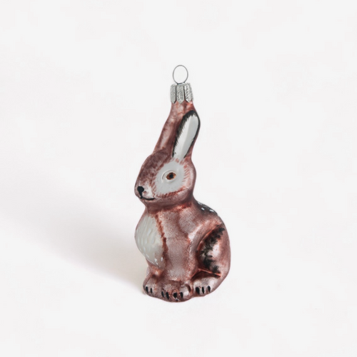 A small glass rabbit ornament with a metallic rose-gold finish, white chest, and dark accents, shown on a plain white background.