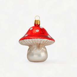 A small mushroom-shaped ornament with a glossy red cap, white polka dots, a white underside, and a pearlescent white stem, topped with a gold loop.