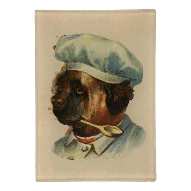 A three and a half inch by five inch rectangular vertical glass tray featuring a vintage-style illustration of a French bulldog wearing a light blue chef's hat and jacket, with a spoon in its mouth, set against a cream-colored background.