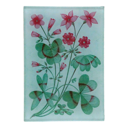 A collage of pink flowers and green leaves design with a light blue back ground on a three and a half inch by five inch glass tray. 