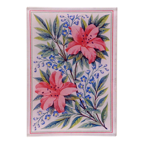 A vibrant floral pattern with a central image of two pink lily flowers surrounded by green leaves and a blue patterned border on a three and a half inch by five inch glass tray. 