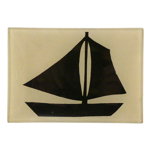 A three and a half inch by five inch horizontal glass tray featuring a bold black silhouette of a sailboat on a cream colored background.