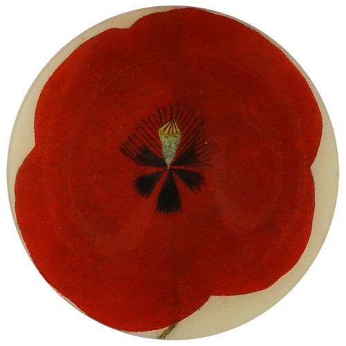 An eleven inch round glass plate of a red poppy flower in the center, with a white border.