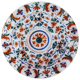 A 13-inch round glass plate featuring a red, green, blue motif on a white background. 