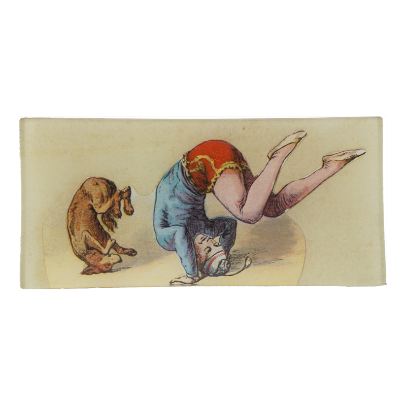 A vintage style illustration of a dog and a person do a flip on a three and a half inch by seven inch glass tray. 