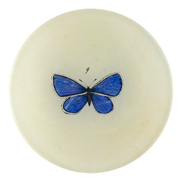 A four inch round handmade decoupage plate with a small blue Butterfly int he center on a cream background