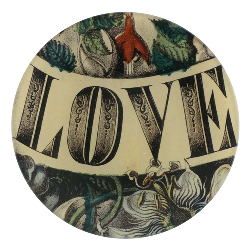 A five inch round glass plate with the word 'LOVE' written in the center in black detailed font. Flowers and foliage surround the word. 