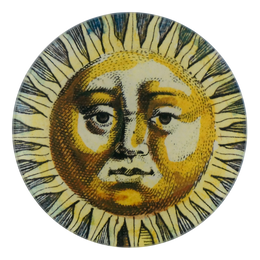 A five inch round glass plate featuring a collage of a face with celestial characteristics on a circular handblown glass base.