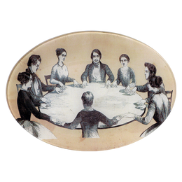 A seven inch by ten inch horizontal oval glass plate of black and white images of people sitting around a table, resembling a seance.