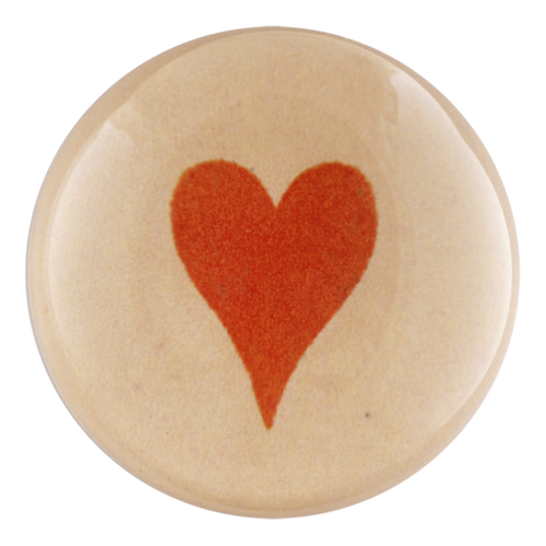 Dome paperweight that 3 inches by 1 inch with a red heart in the center. 
