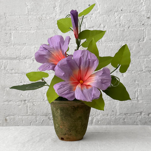 Colorful paper flowers in pot on table