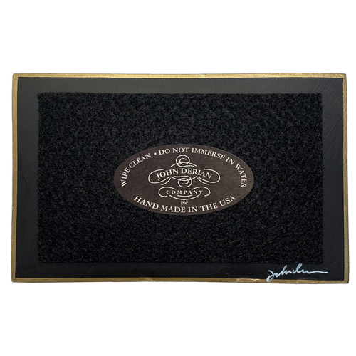 The back of a three and a half inch by five inch tray painted black with black felt and a painted gold boarder. Featuring the John Derian Company logo and sign signed by John Derian. 