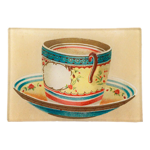 An illustration of a blue, yellow and red tea cup on a beige background. This is a three and a half inch by five inch glass tray. 